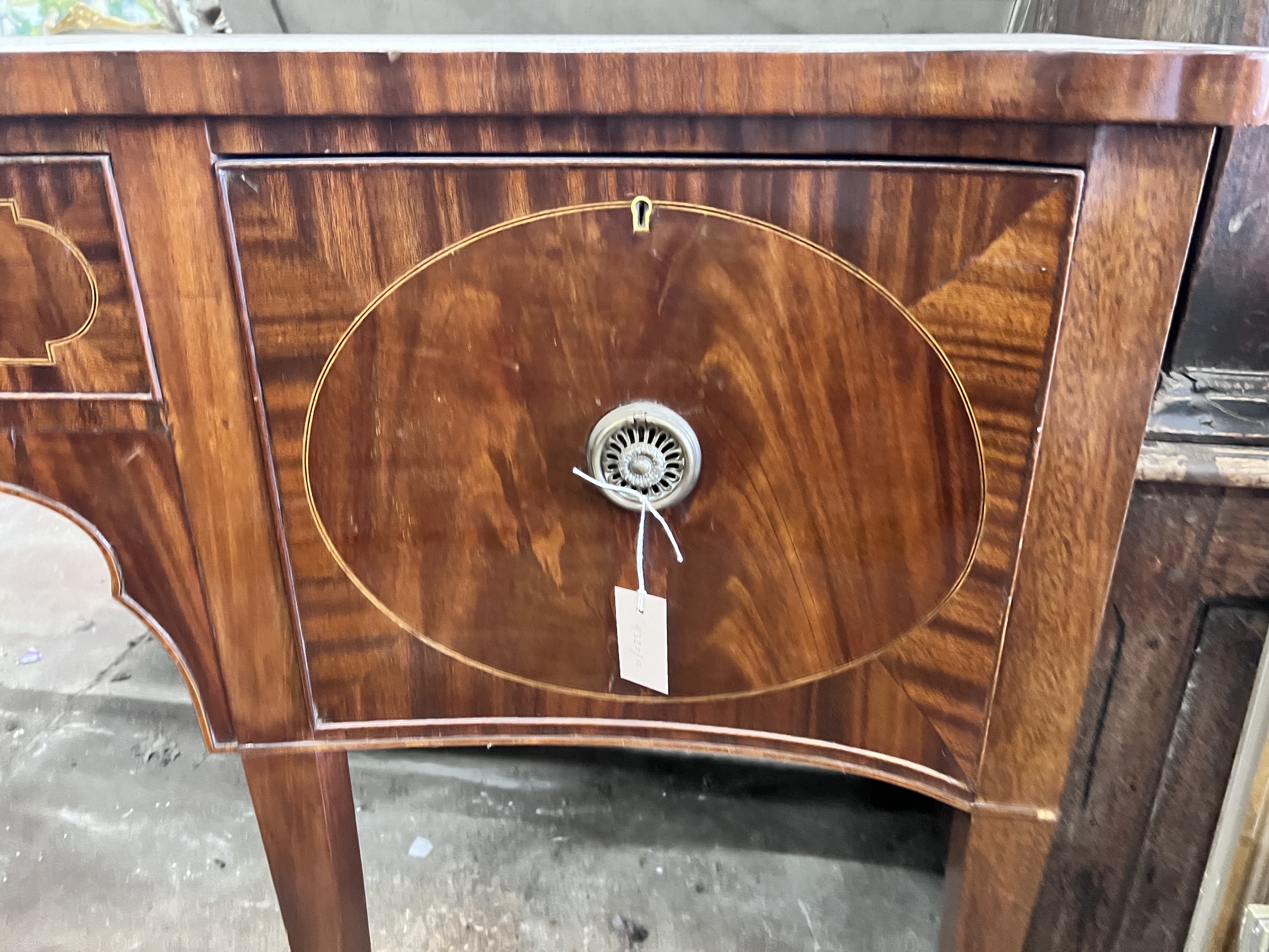 A George III style mahogany serpentine sideboard on square tapered legs, width 184cm, depth 63cm, height 93cm